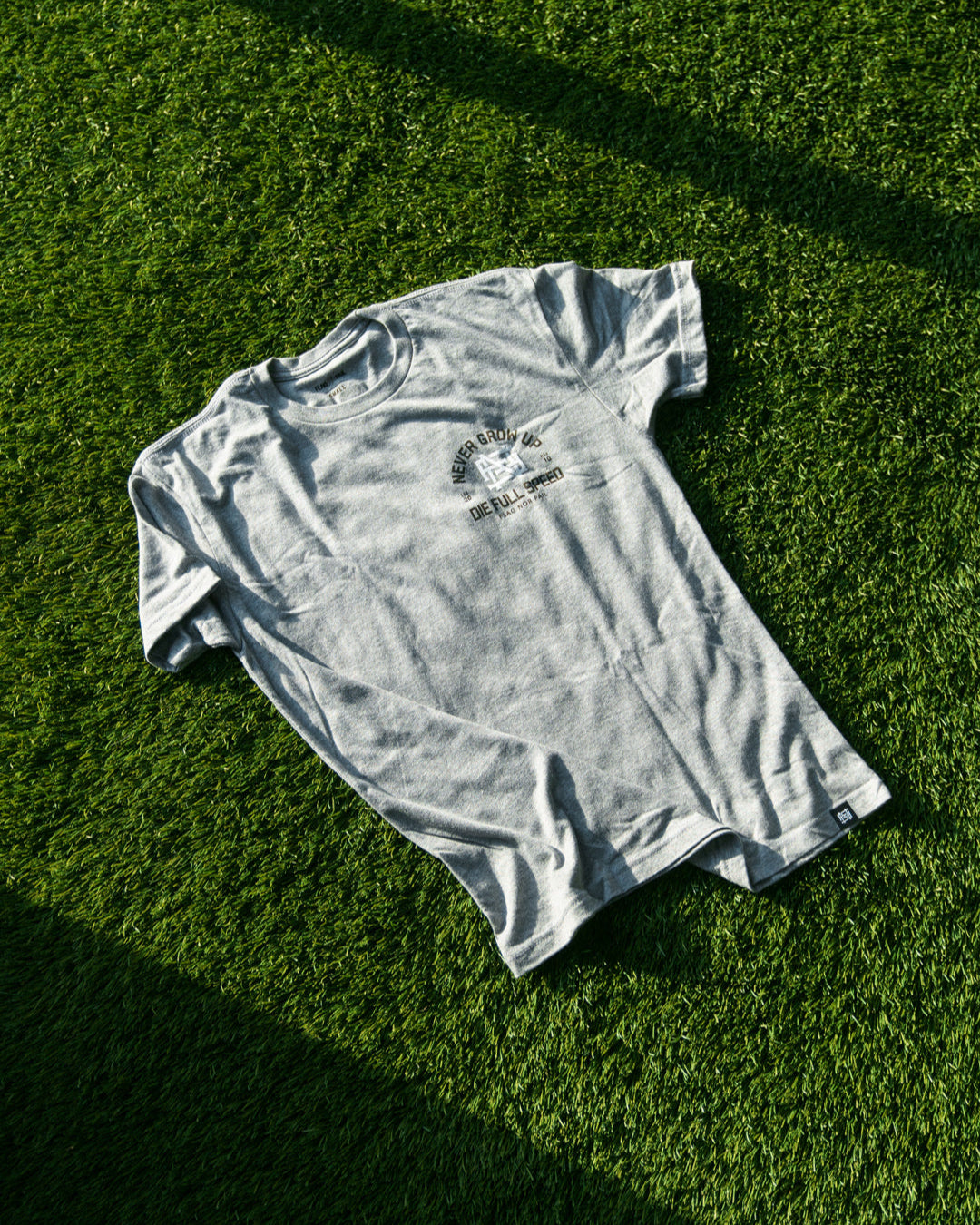 Gray t-shirt on a green grass surface