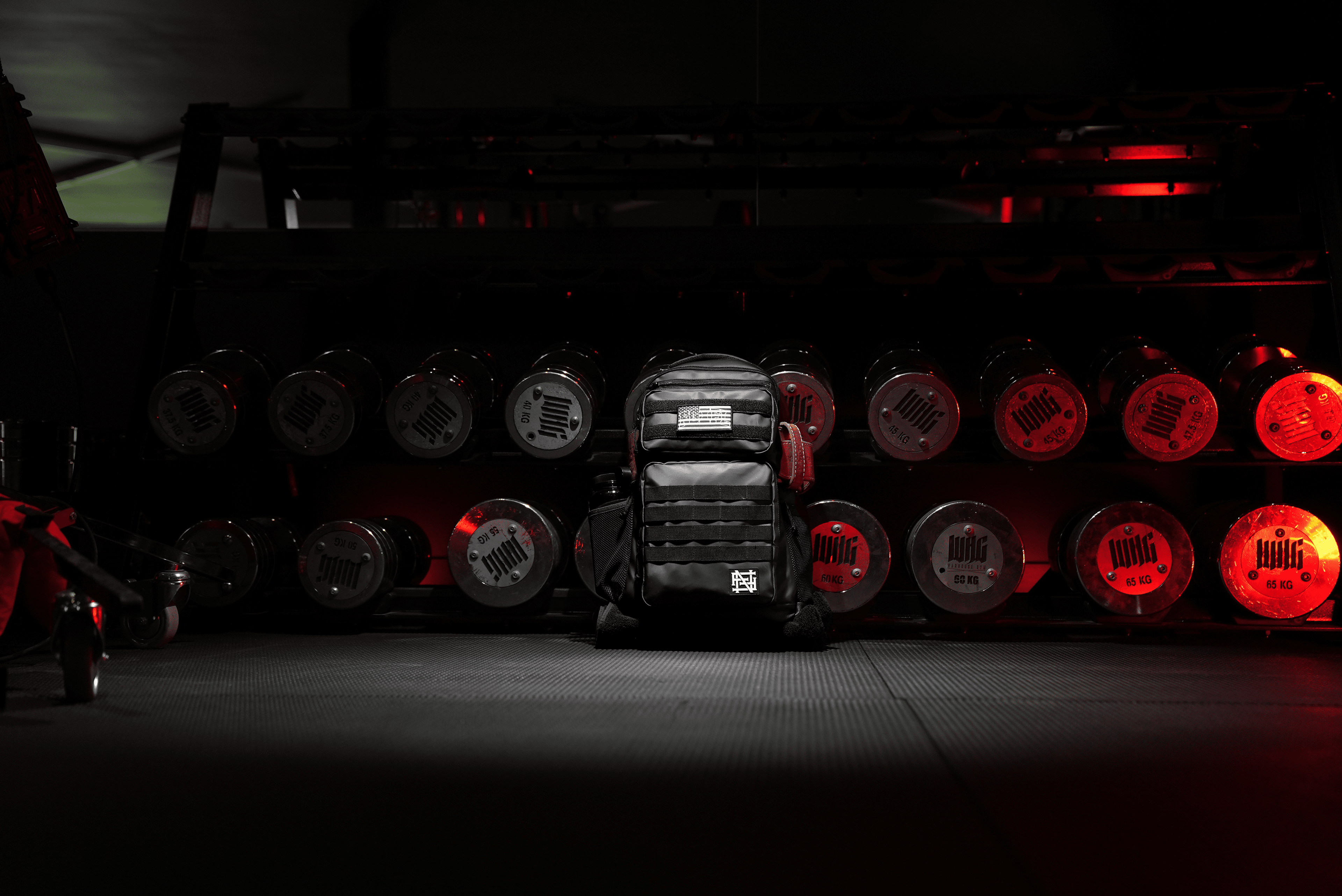 Banner of Momentum Pro Backpack in a dark room with a weight rack behind it