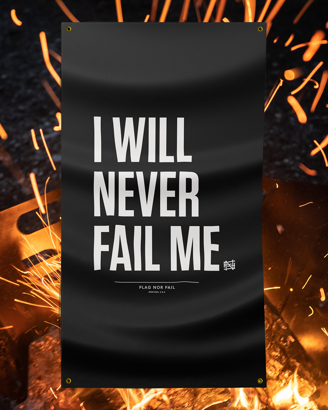 A rectangular flag with the text 'I WILL NEVER FAIL ME' in bold white letters on a black background, displayed in a fiery backdrop.