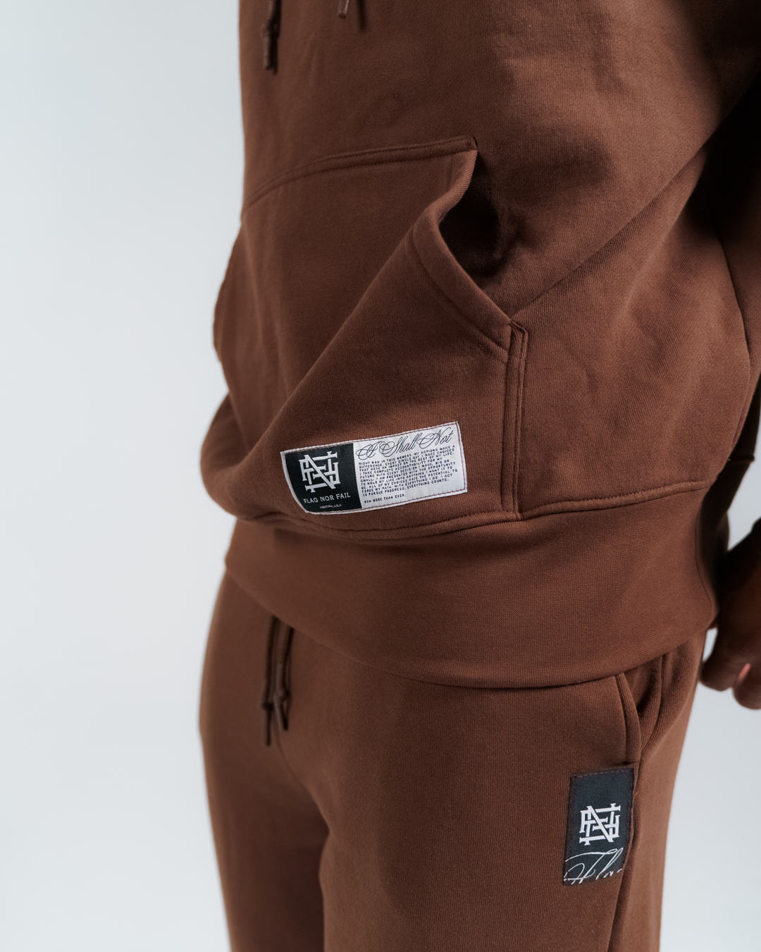 Brown hoodie with visible brand label on a white background