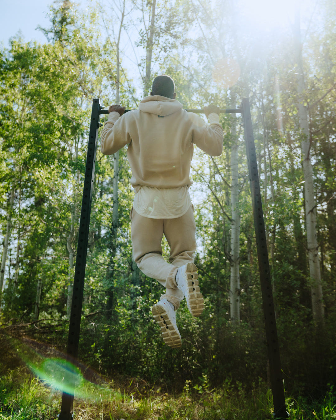 Person doing a pull-up in a forest setting