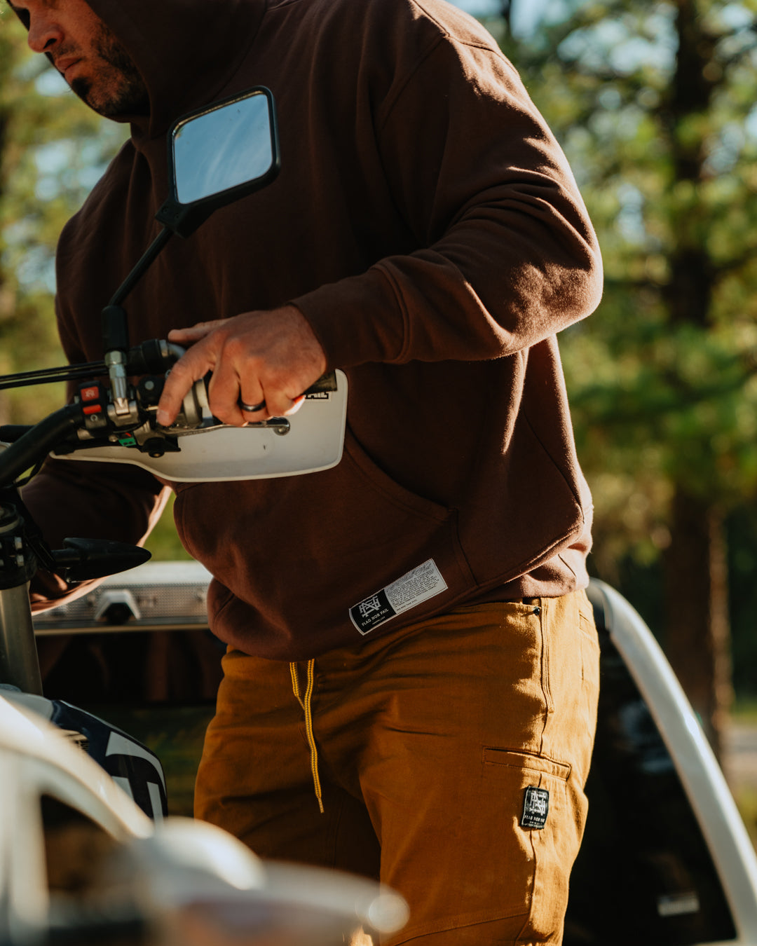 Person in brown hoodie and pants on a motorcycle