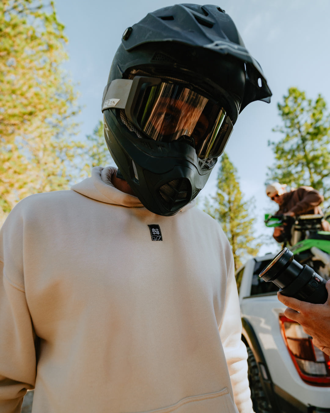 Person wearing a helmet and beige hoodie with a blurred background