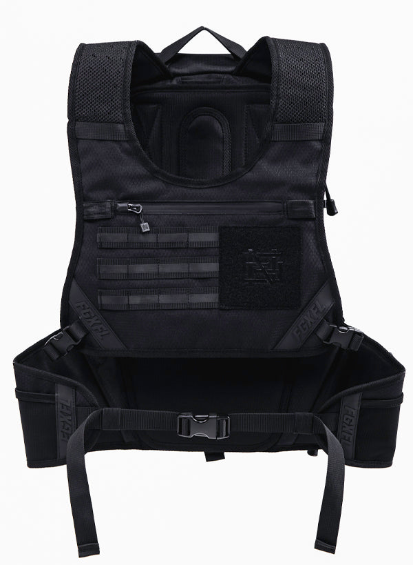 The front of our black Apex bag. Featuring a tactical chest rig. There is a zipper compartment with a water resistant zipper. Below there are tactical webbing for accessories (sold separately). To the right of the webbing is a black fabric area featuring our monogram Flag nor Fail logo. In this area separately sold patches can be attached via Velcro. The photo also shows that the waist can be secured with a buckle.