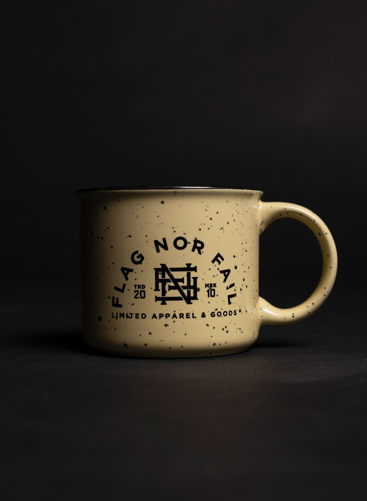 Ceramic mug. Almond color speckled black. Featuring a black Flag nor Fail logo.